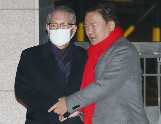 구속기간 만료로 석방된 김기춘 전 대통령 비서실장(왼쪽)이 4일 서울 송파구 동부구치소를 나선 뒤 마중 나온 자유한국당 민경욱 의원의 손을 잡고 차량으로 향하고 있다. <연합뉴스>